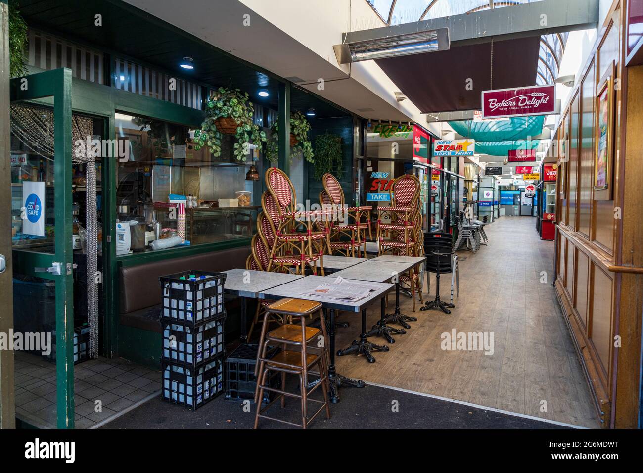 Geschlossene Cafés mit gestapelten Stühlen, in einer Arkade in Balmain, Sydney, Australien während einer Pandemie-Sperre Stockfoto