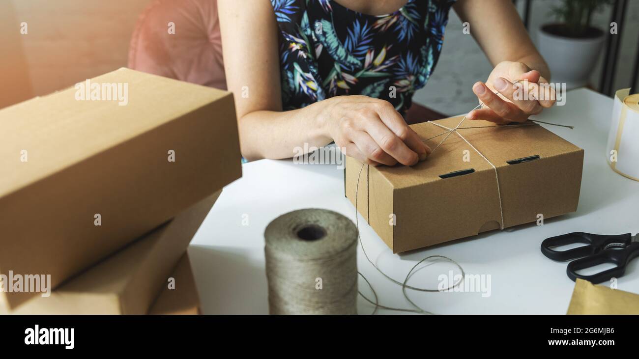Kleine Online-Geschäft Eigentümer Verpackung Paket-Box zu Hause, um Produkt an den Kunden zu liefern. Banner Stockfoto