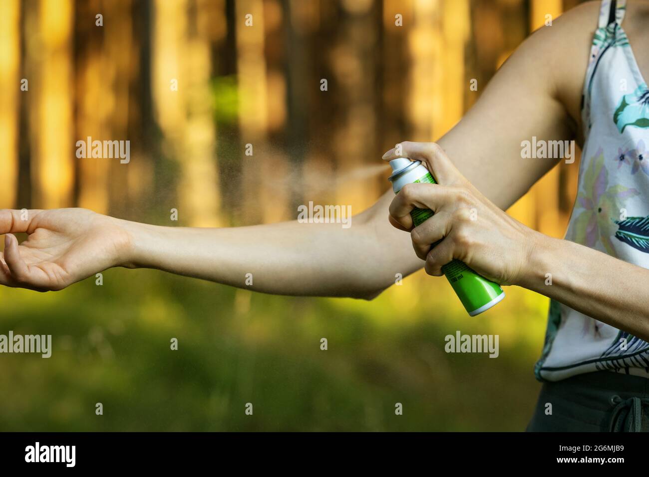 Frau, die im Wald Insekt- und Mückenspray auf die Hand gibt Stockfoto