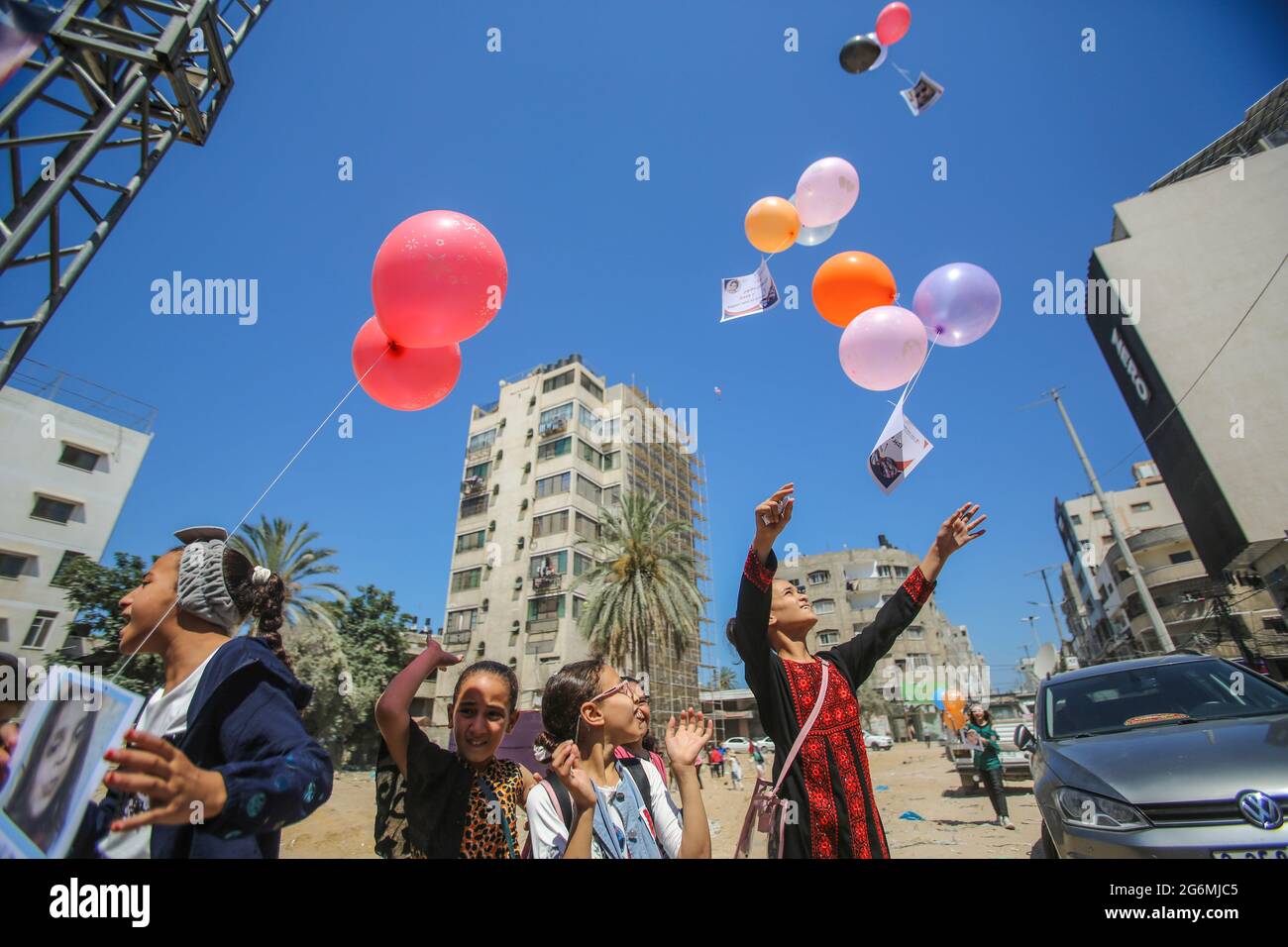 Gaza, Palästina. Juli 2021. Palästinensische Kinder lassen Ballons als Botschaft an die internationale Gemeinschaft frei. In der al-wahda-Straße in Gaza-Stadt fügten Kinder Botschaften in Ballons ein und ließen sie in die Luft, damit sie „der Welt“ und der internationalen Gemeinschaft, die den Wiederaufbau des Gazastreifens, das Ende der Belagerung und ein sicheres und würdiges Leben im Gazastreifen forderte, „die Welt“ und „die Welt“ schützen können. (Foto von Ahmed Zakot/SOPA Images/Sipa USA) Quelle: SIPA USA/Alamy Live News Stockfoto