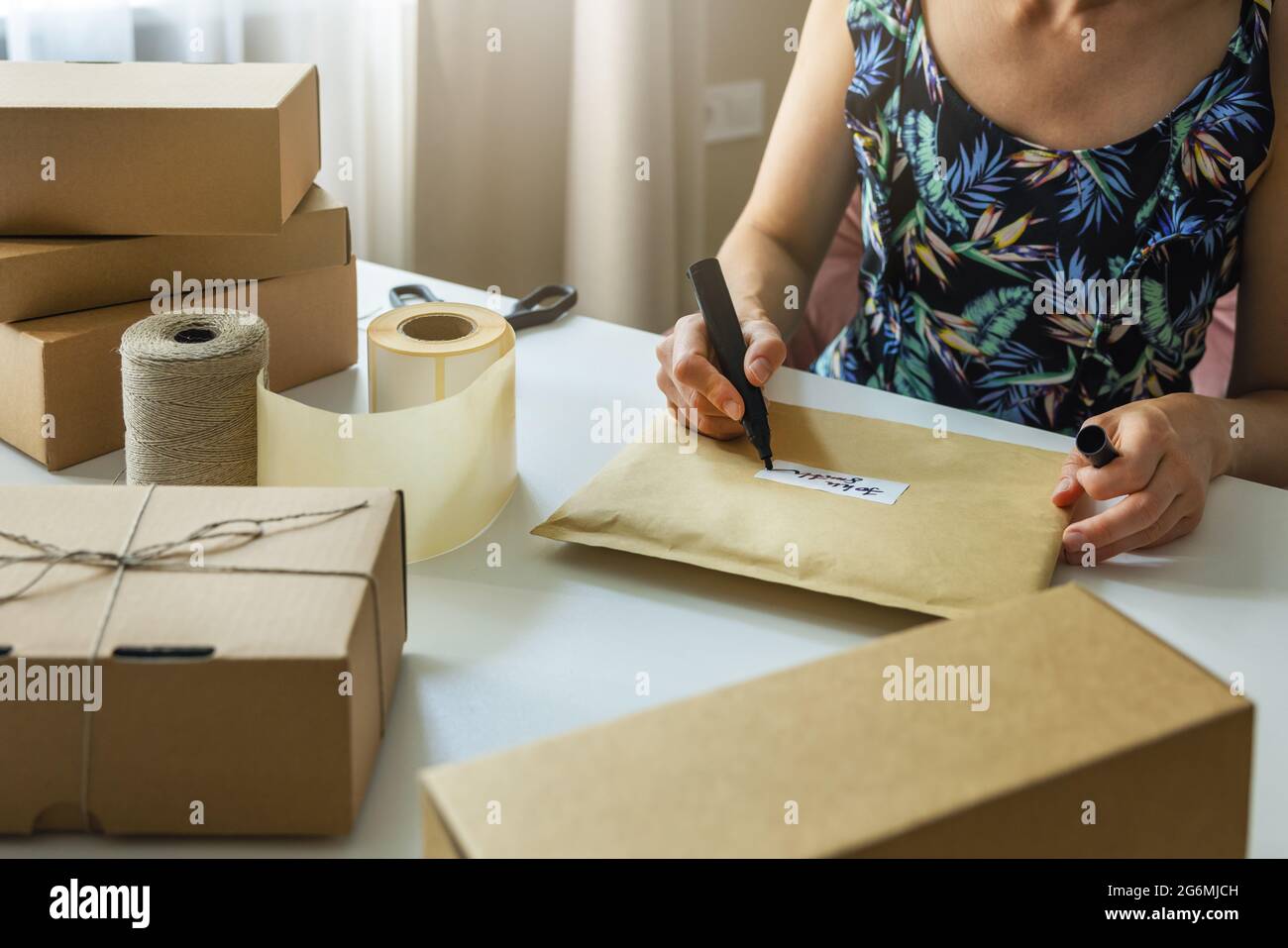Kleiner Online-Shop Besitzer Briefumschlag Versandetikett zu Hause für die Lieferung Stockfoto