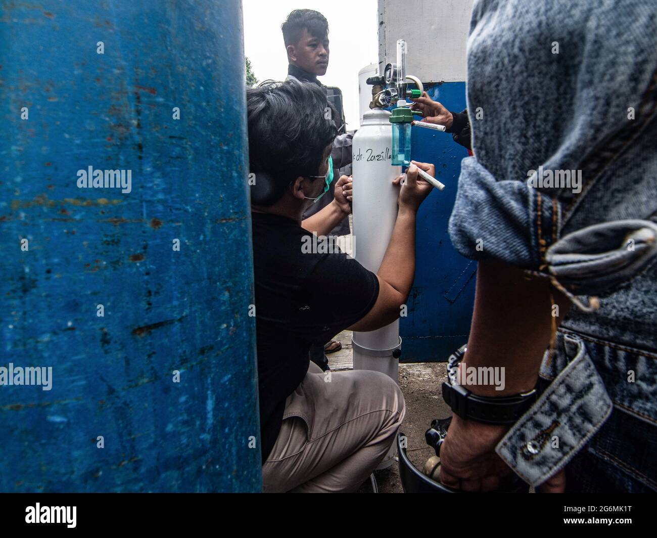 Jakarta, Indonesien. Juli 2021. Verwandte von Covid-19-Patienten warten vor einem Sauerstofffüllzentrum, um ihre leeren Flaschen aufzufüllen, da die Nachfrage nach dem Gas aufgrund der Spitzen bei Coronavirus-Fällen steigt. Der Anstieg der schrecklichen Coronavirus-Fälle hat in Indonesien zu Sauerstoffmangel geführt, wie der Sauerstofflieferant am Dienstag mitteilte. Kredit: SOPA Images Limited/Alamy Live Nachrichten Stockfoto