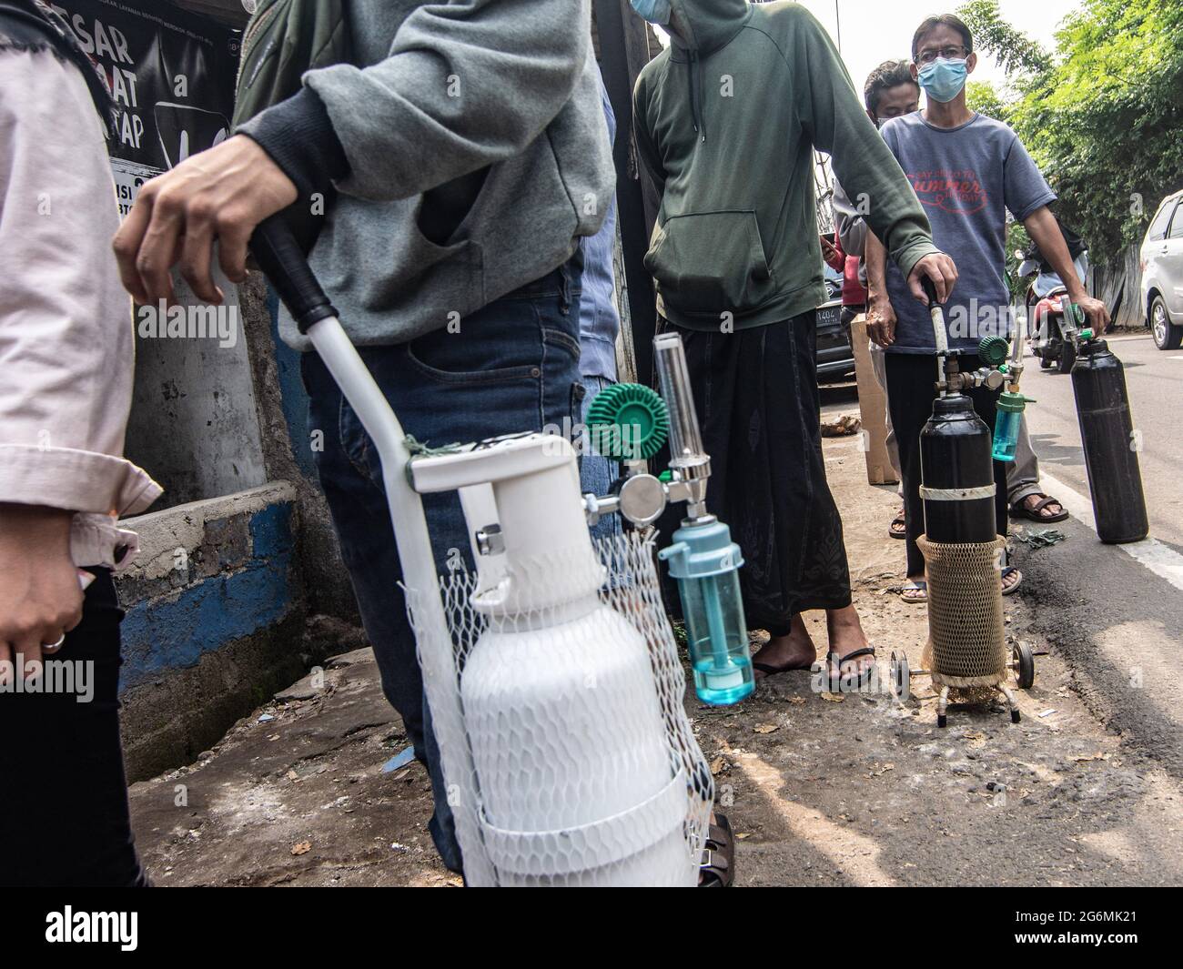 Jakarta, Indonesien. Juli 2021. Verwandte von Covid-19-Patienten warten vor einem Sauerstofffüllzentrum, um ihre leeren Flaschen aufzufüllen, da die Nachfrage nach dem Gas aufgrund der Spitzen bei Coronavirus-Fällen steigt. Der Anstieg der schrecklichen Coronavirus-Fälle hat in Indonesien zu Sauerstoffmangel geführt, wie der Sauerstofflieferant am Dienstag mitteilte. Kredit: SOPA Images Limited/Alamy Live Nachrichten Stockfoto