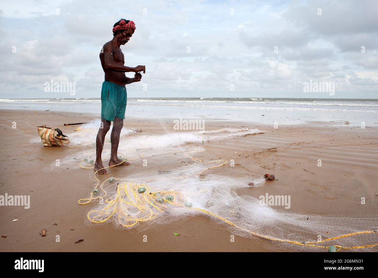 Fischer, die sich mit dem Fischernetz am Strand vorbereiten, bevor sie zum Angeln ins Meer gehen. Stockfoto