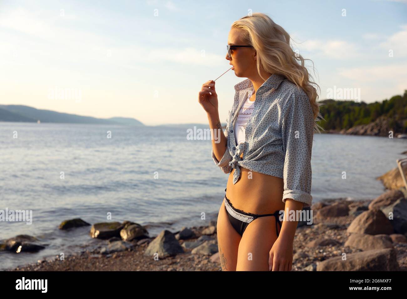 Schöne Blonde Junge Frau Beim Essen Von Aromatisiertes Eis Am Strand Stockfoto