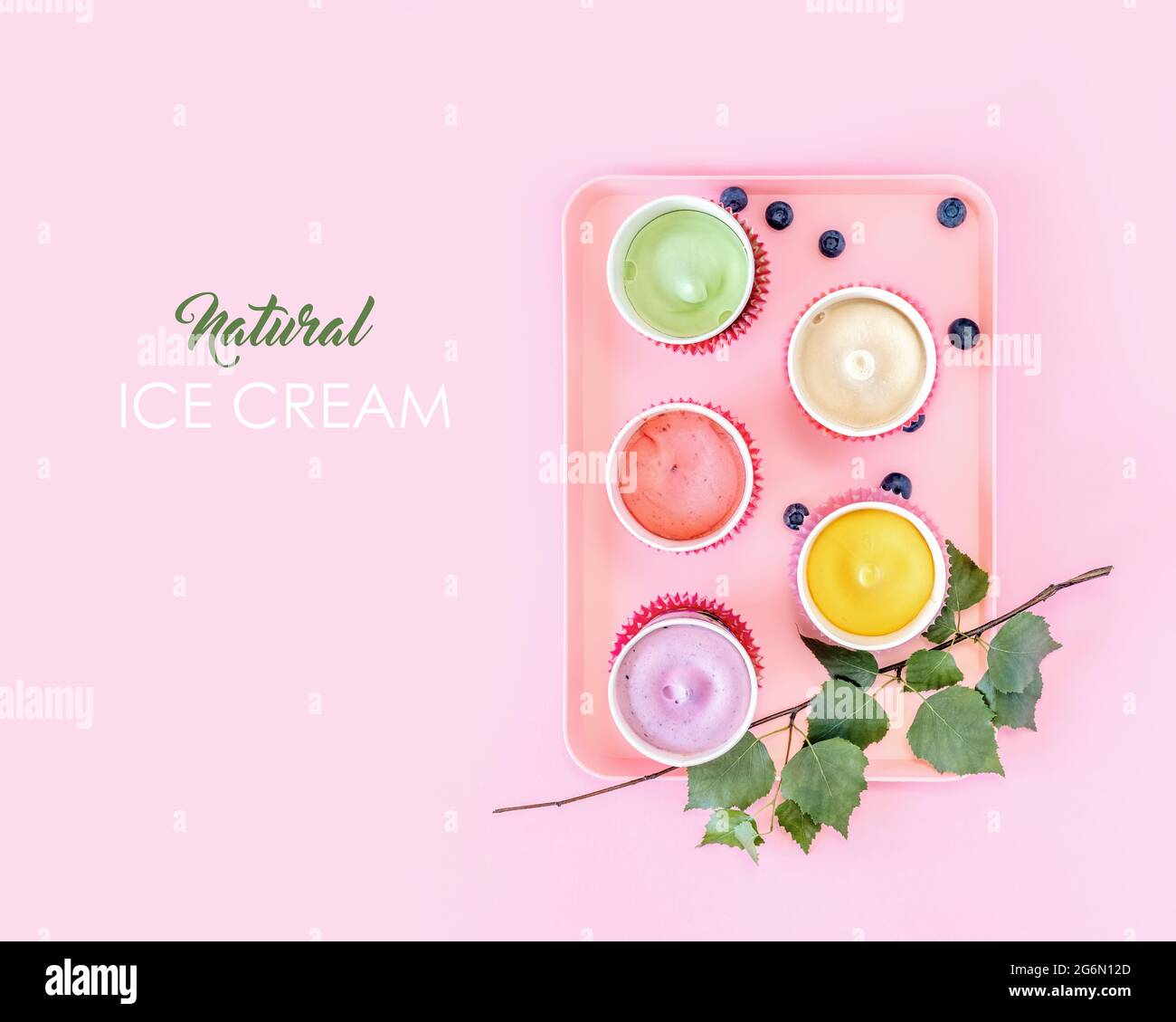 Verschiedene hausgemachte, natürliche, vegane Eiscreme auf einem rosa Tablett auf einem rosa Hintergrund mit Kopierfläche. Gefrorene Früchte oder Beeren Joghurt in Tassen Stockfoto