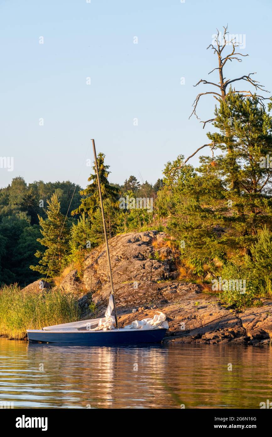 Helsinki / Finnland - 3. JULI 2021: Festfahrende Segelboote, die während des Sonnenuntergangs am Ufer schweben. Stockfoto