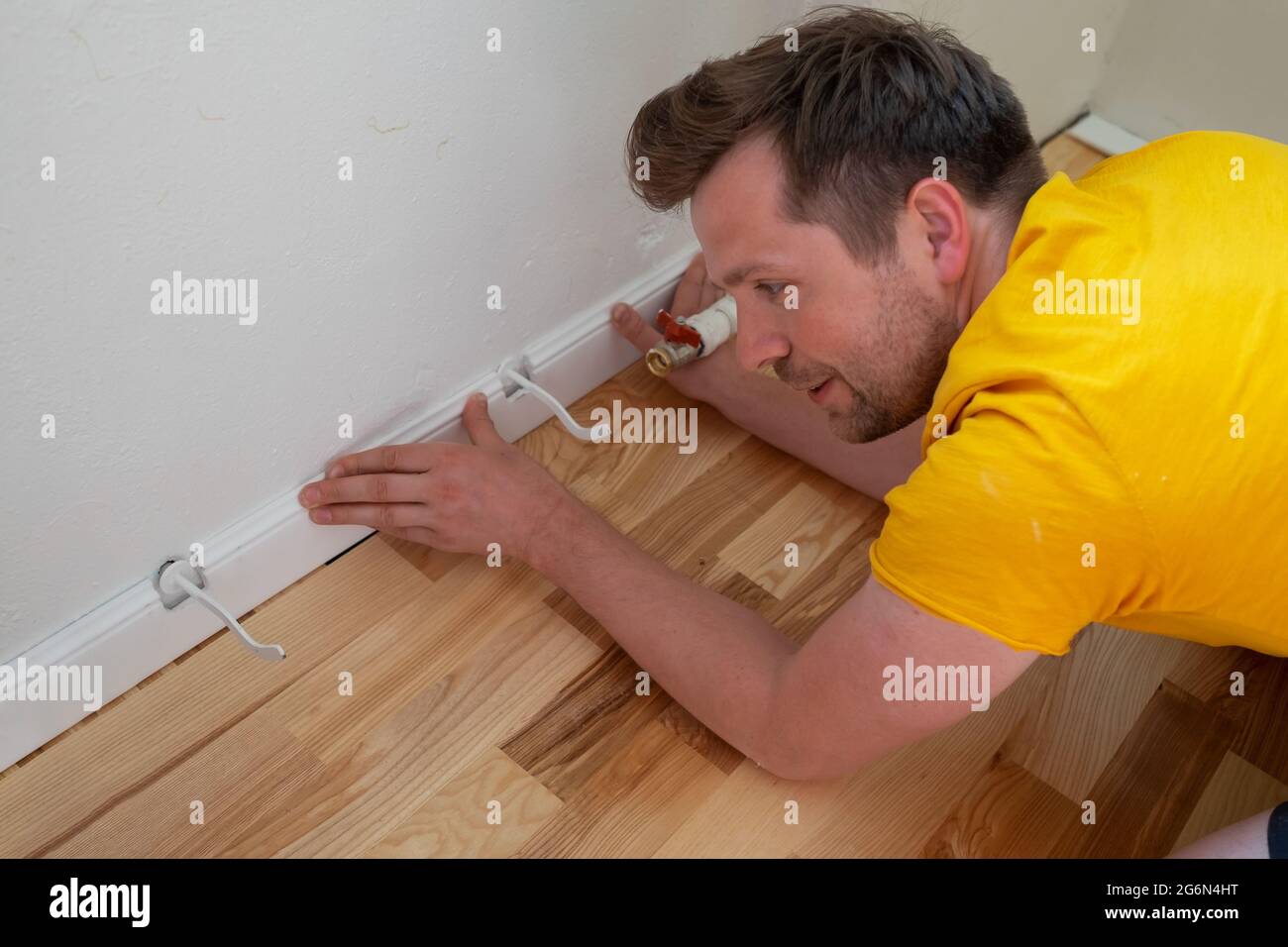 Blick auf männliche Hände, die an die Fußleiste passen Stockfoto