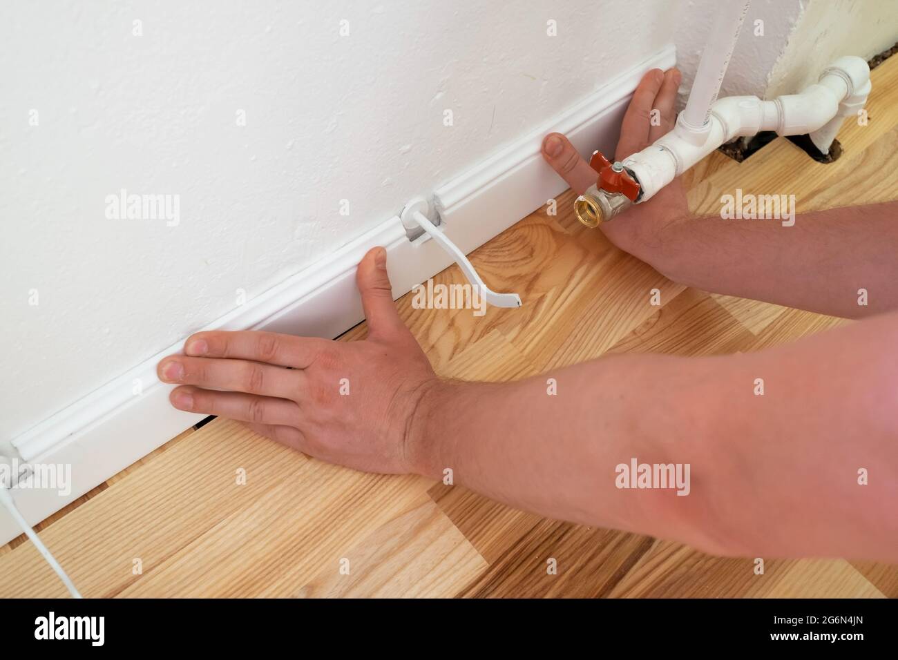 Blick auf männliche Hände, die an die Fußleiste passen Stockfoto