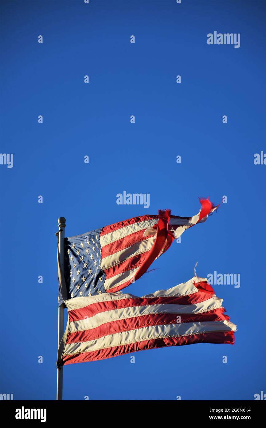 Der Wind hat diese amerikanische Flagge zerstört und muss wegen der Schäden durch Wind in Zentralkalifornien in einem Privathaus auf dem Bauernhof ersetzt werden Stockfoto