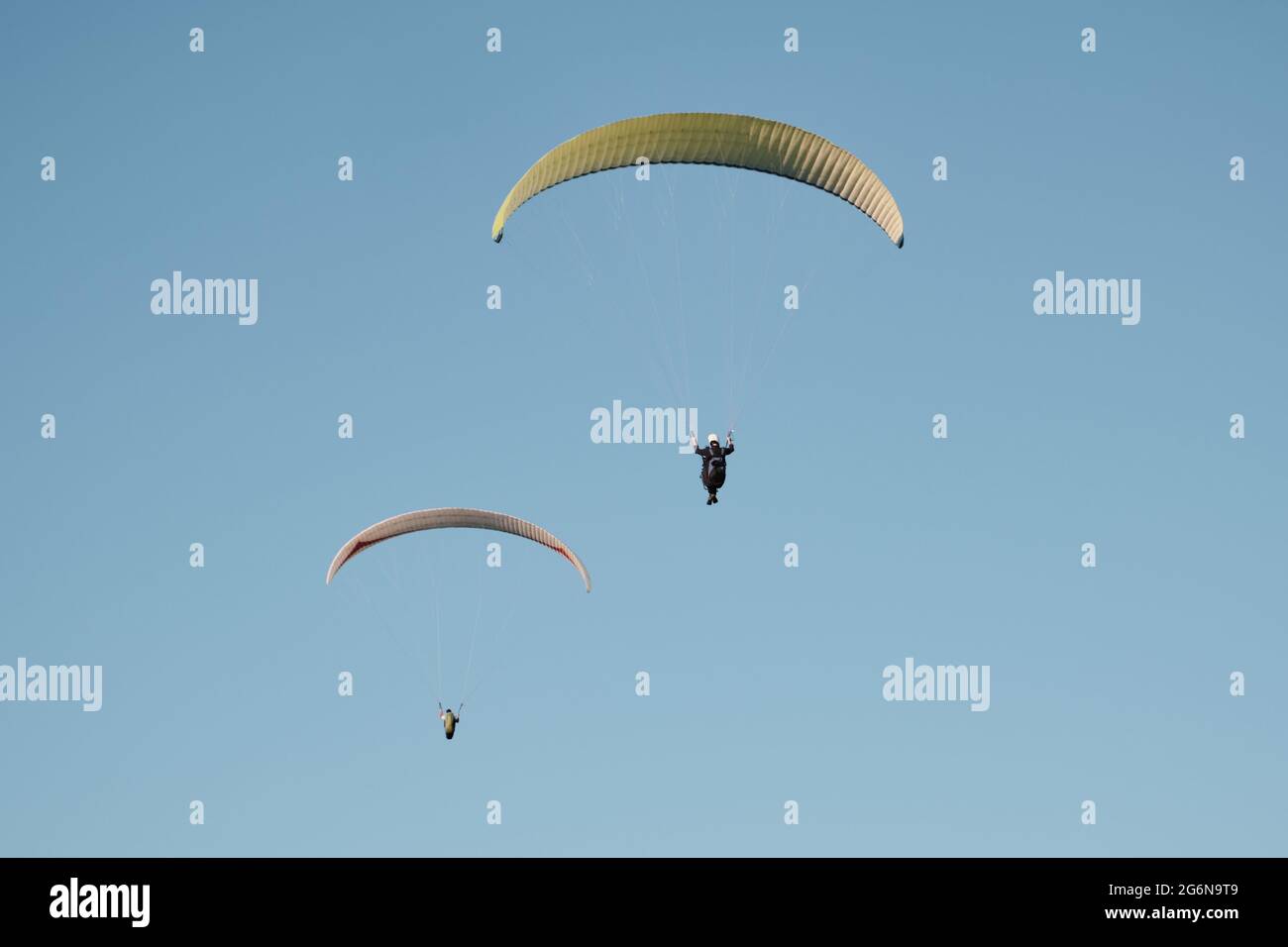 Gleitschirm gegen den blauen Himmel. Flugsport... Aktive Erholung außerhalb der Stadt. Stockfoto