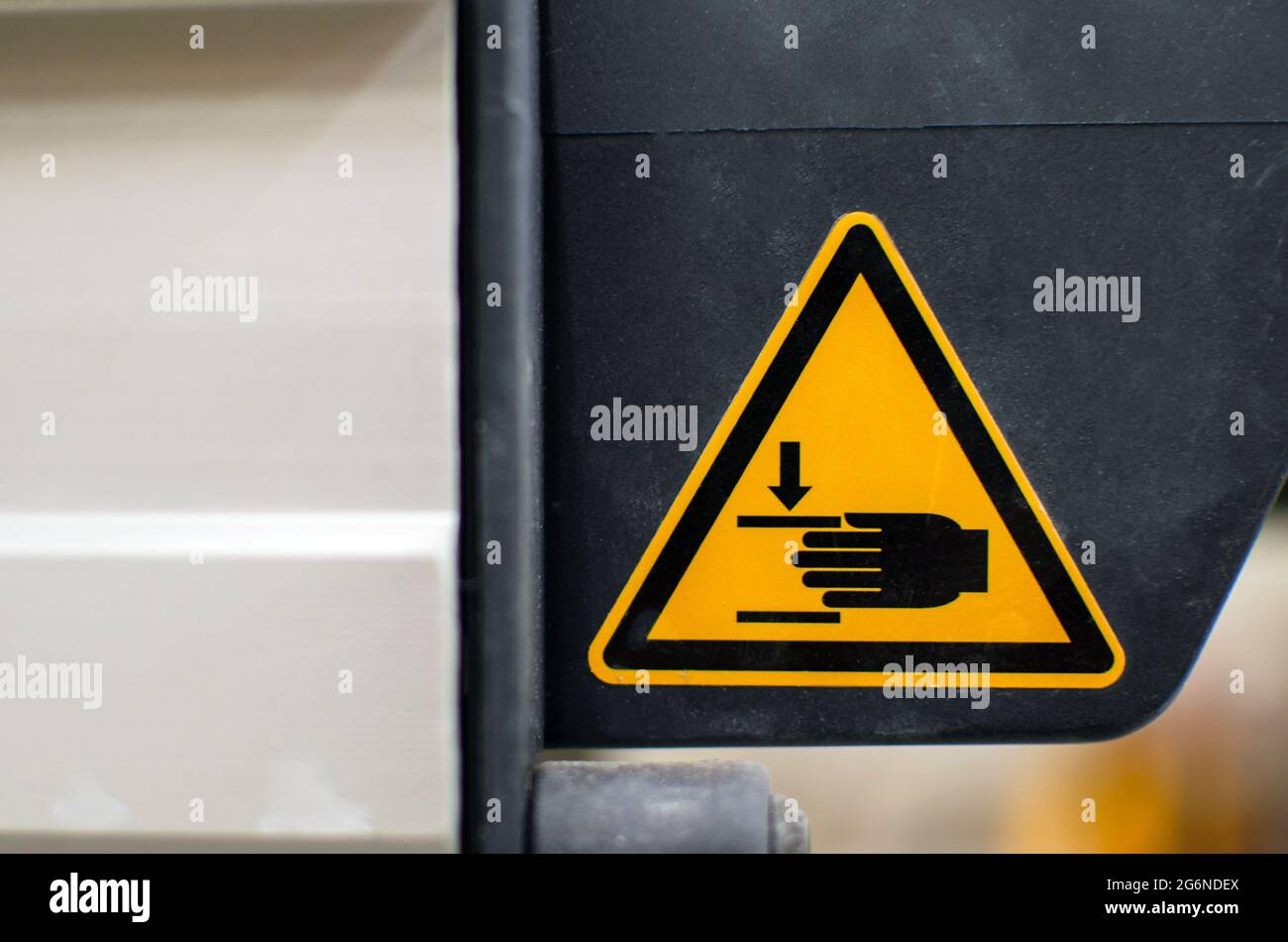 Warnschild an Landmaschinen. Legen Sie Ihre Hände nicht heraus. Verletzungen der Hände sind möglich. Seien Sie aufmerksam. Stockfoto