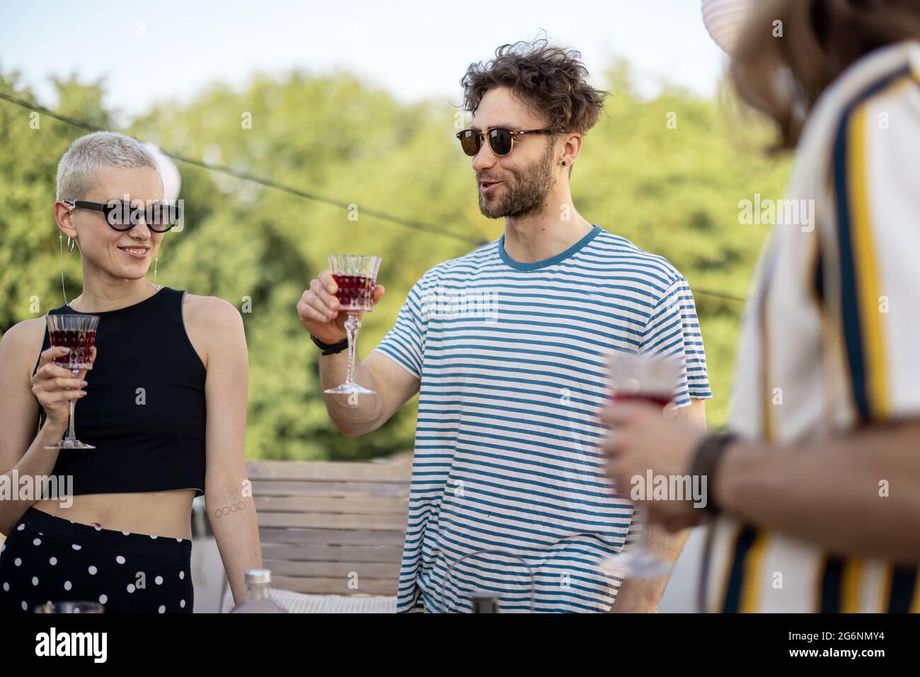 Junge, stilvolle Freunde bei einem festlichen Abendessen auf der Dachterrasse Stockfoto