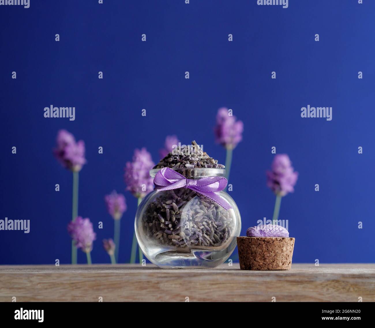 Getrocknete Lavendelknospen in einem kleinen Glas auf einem Tisch mit frischen Lavendelblüten. Aromatische Kräuter der Provence. Stockfoto