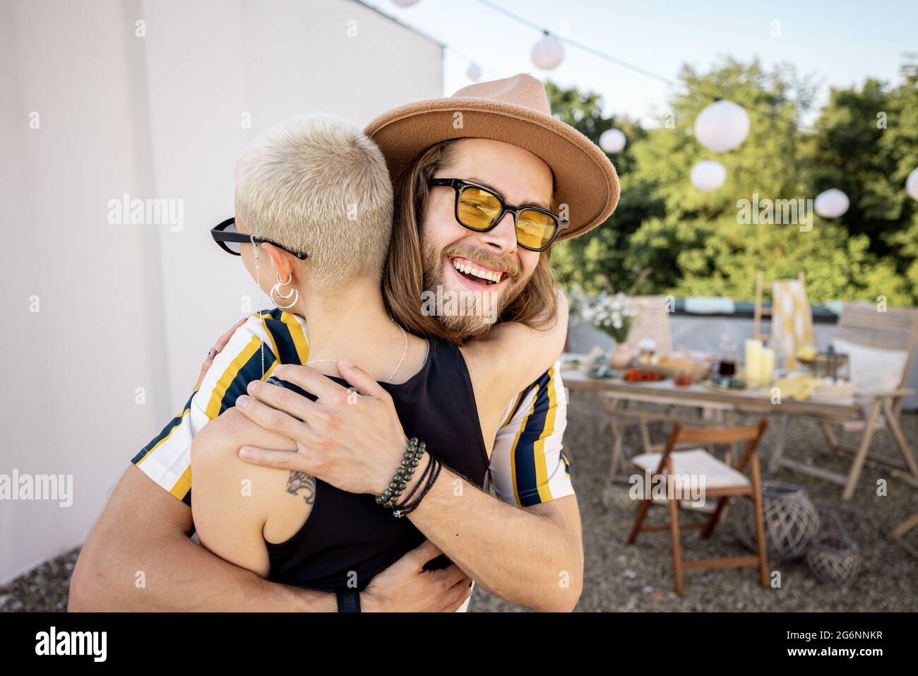 Junge, stilvolle Freunde grüßen bei der Party im Freien Stockfoto