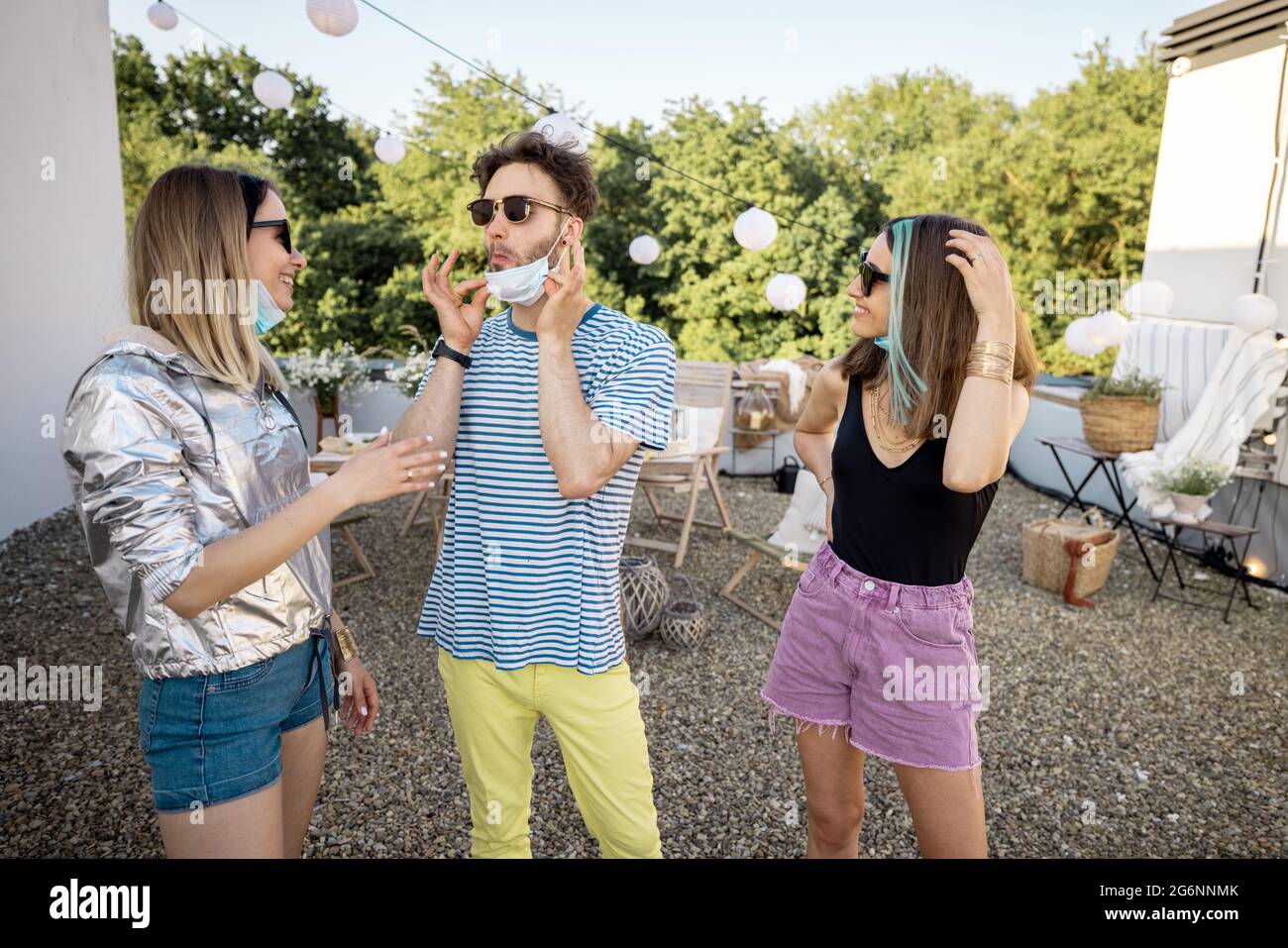 Freunde in Gesichtsmasken versammeln sich auf einer Party Outdoors Stockfoto