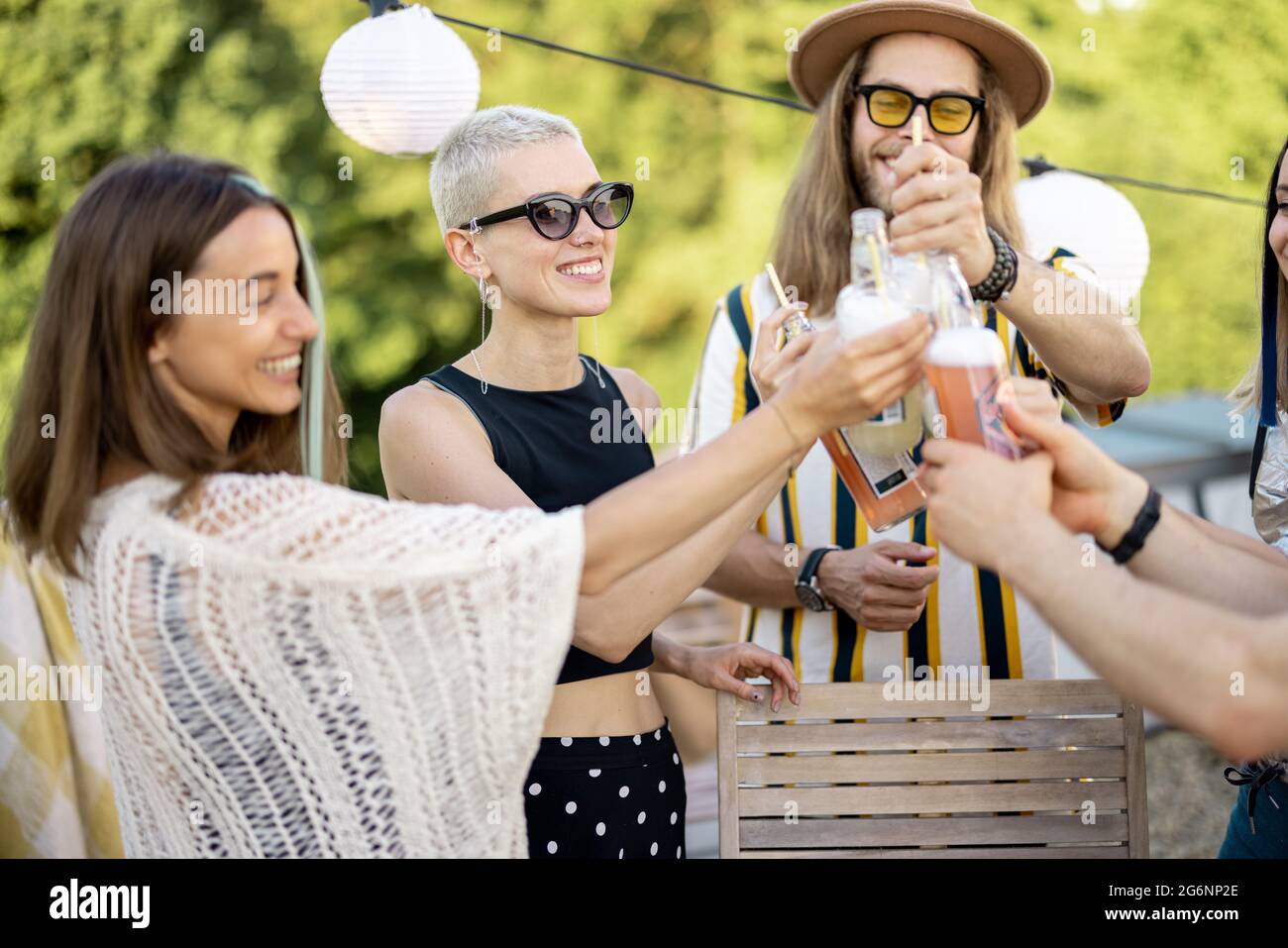 Junge, stilvolle Freunde bei einem festlichen Abendessen auf der Dachterrasse Stockfoto