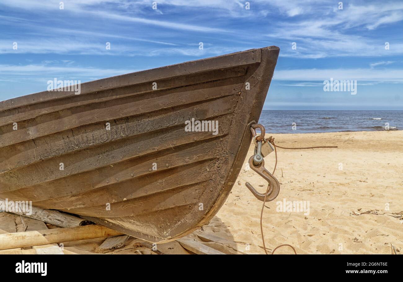 Altes Fischerboot aus Holz am Strand. Blauer Himmel mit weißen Wolken. Sonniger Tag Stockfoto