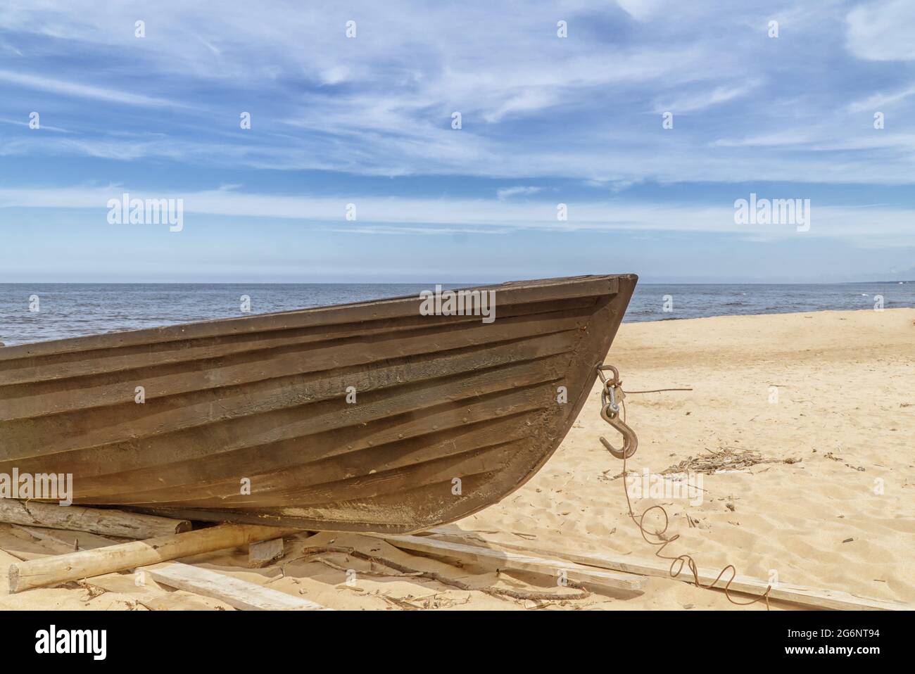 Altes Fischerboot aus Holz am Strand. Blauer Himmel mit weißen Wolken. Sonniger Tag Stockfoto