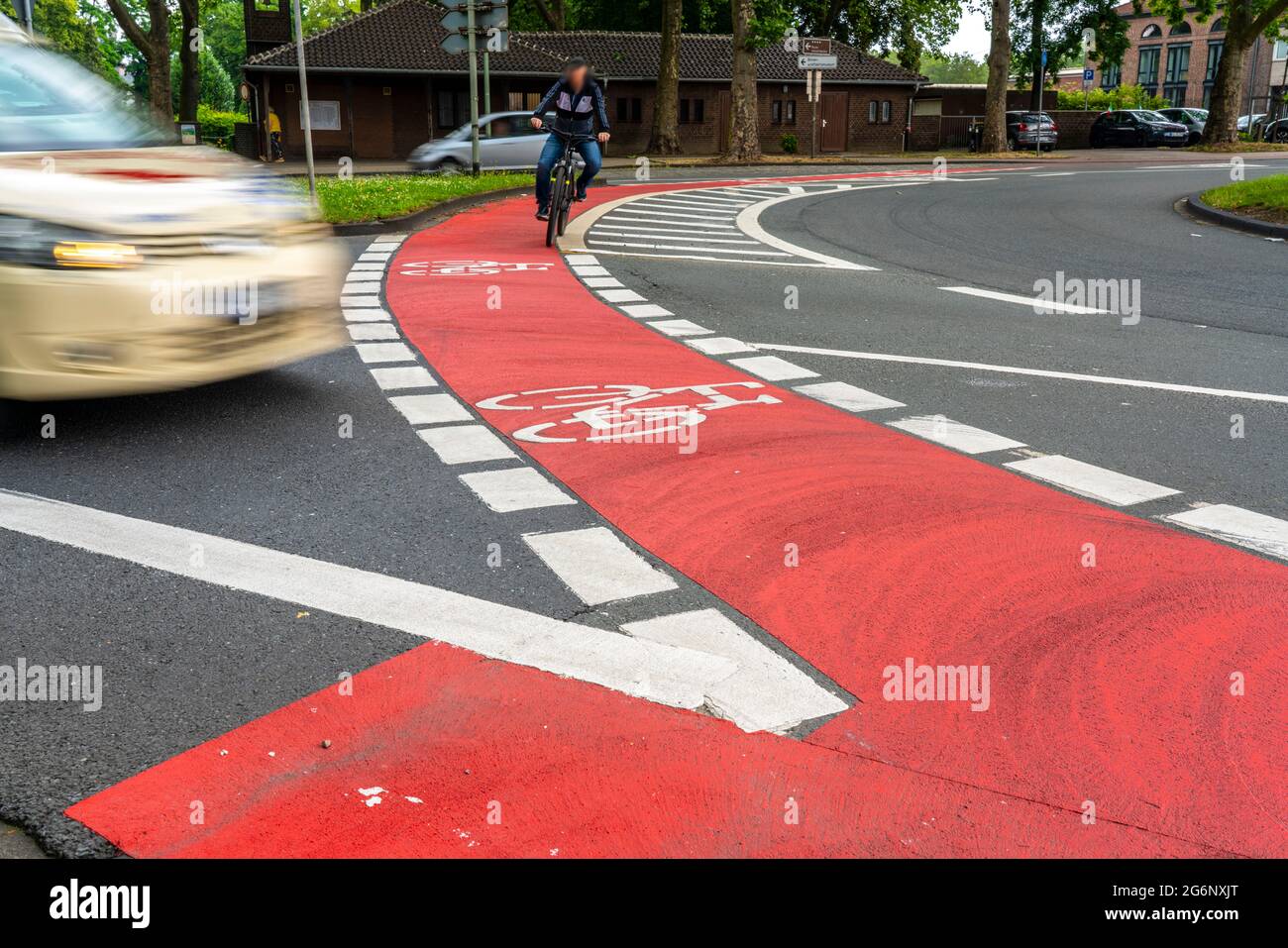 Rote Radfahrbahn Markierung in einem innerstädtischen Kreisverkehr, um Fahrer darauf aufmerksam zu machen, dass Radfahrer auch an Kreisverkehren Vorfahrtsrecht haben, Unfallschwerpunkt Stockfoto