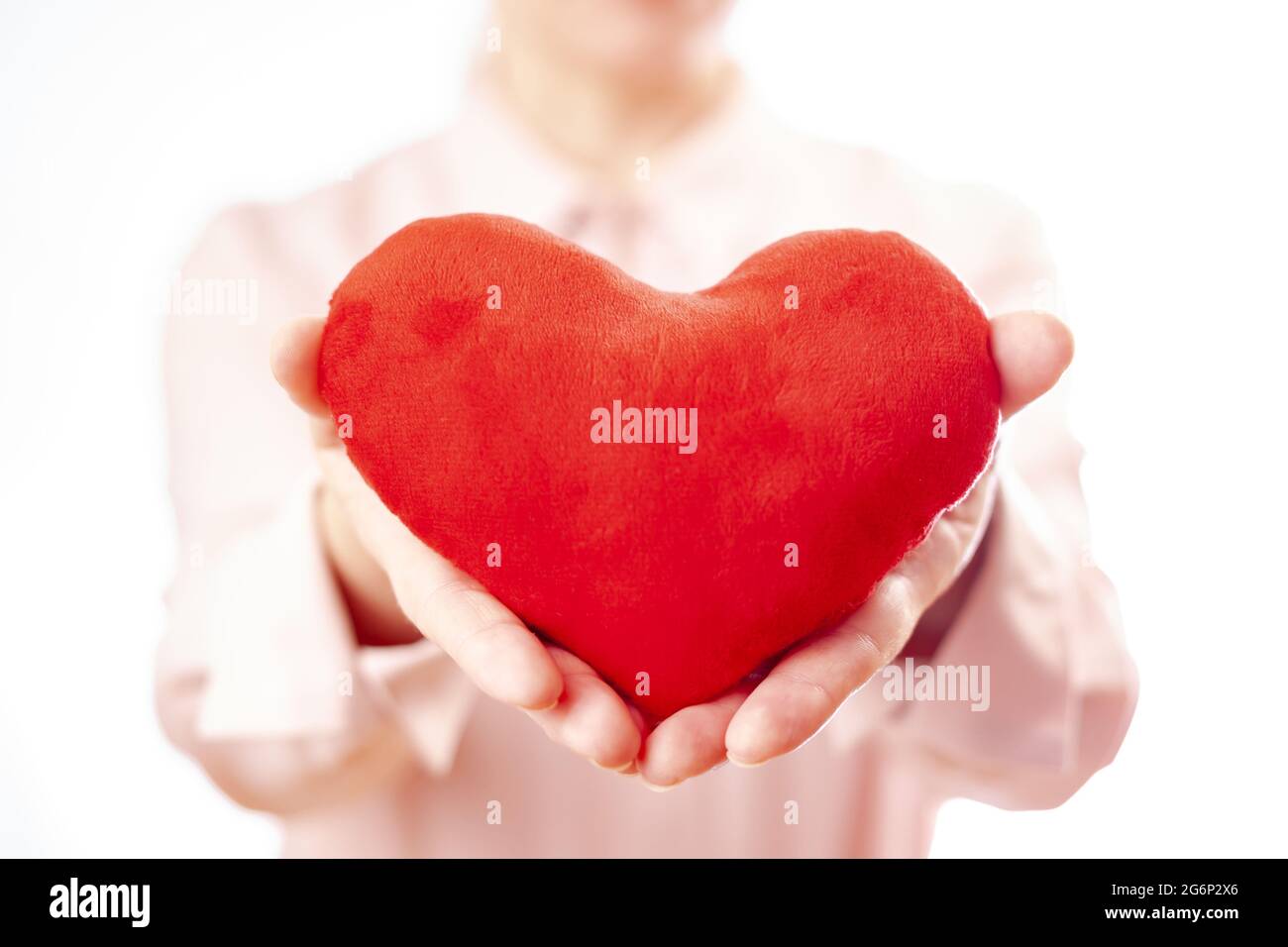 Frau hält Plüsch Herz, weibliche Liebe. Weißer Hintergrund Stockfoto