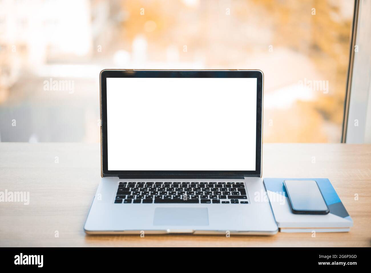 Laptop auf dem Tisch mit leerem leerem Bildschirm nachmachen. Modernes Technologiekonzept, Unternehmensportfolio oder Werbedesign auf Computergeräten Stockfoto