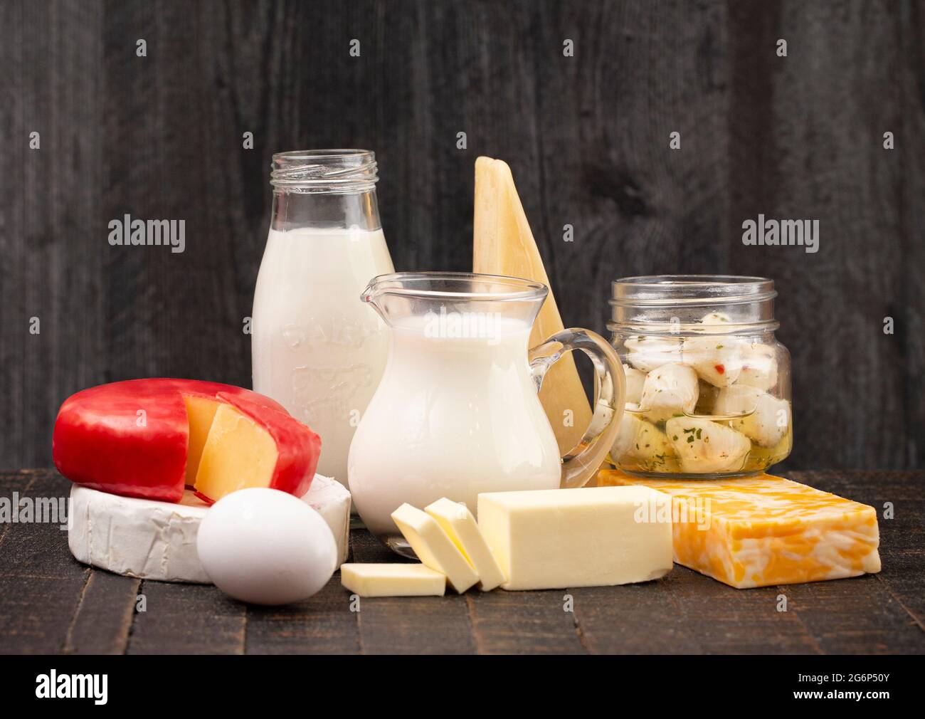 Eine Gruppe verschiedener Milchprodukte auf einem rustikalen Holztisch Stockfoto