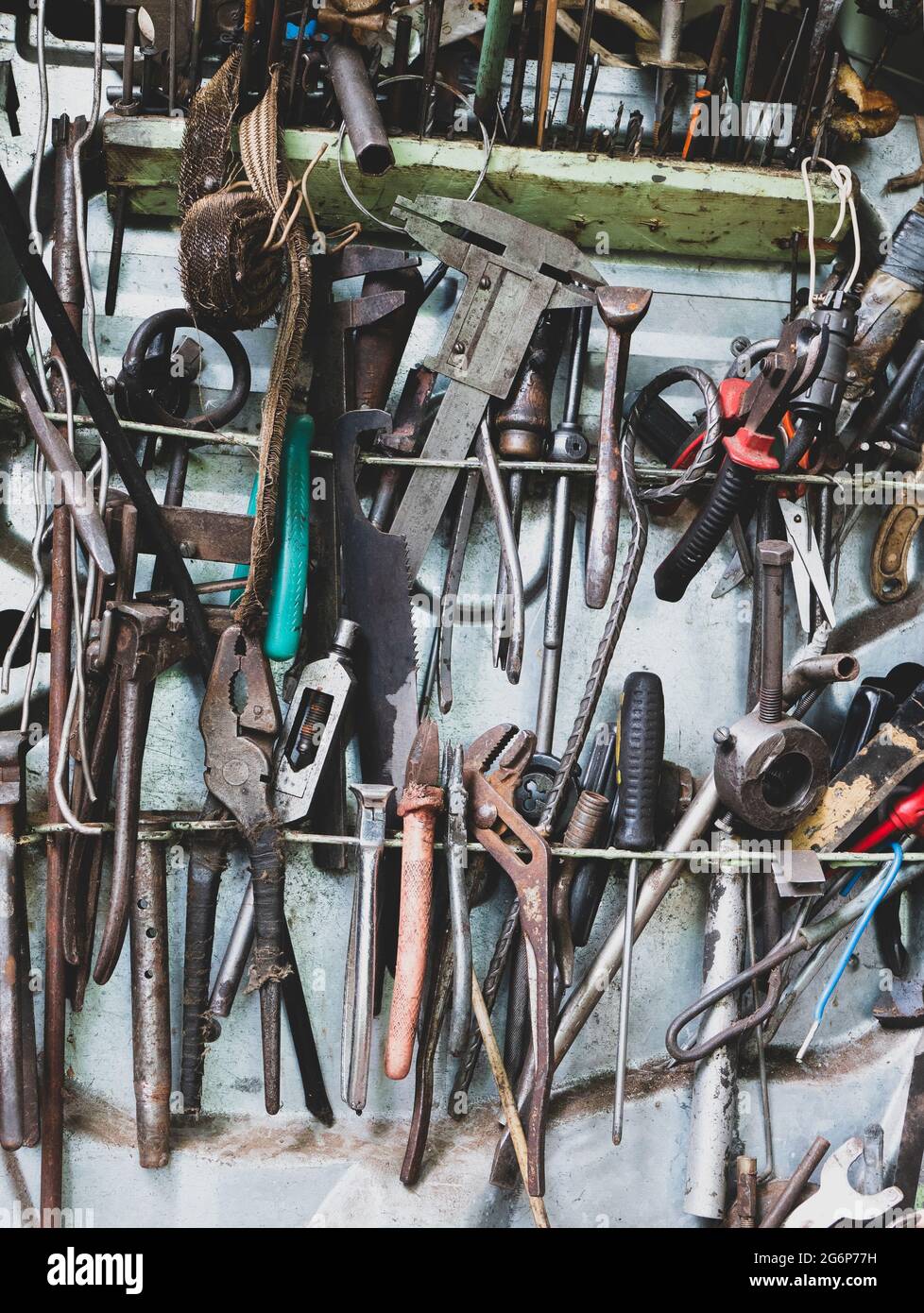 Viele alte und rostige Handwerkzeuge. Detail des Arbeitsplatdes Mechanikers in der Garage. Toolkit für Reparaturwerkstätten Stockfoto