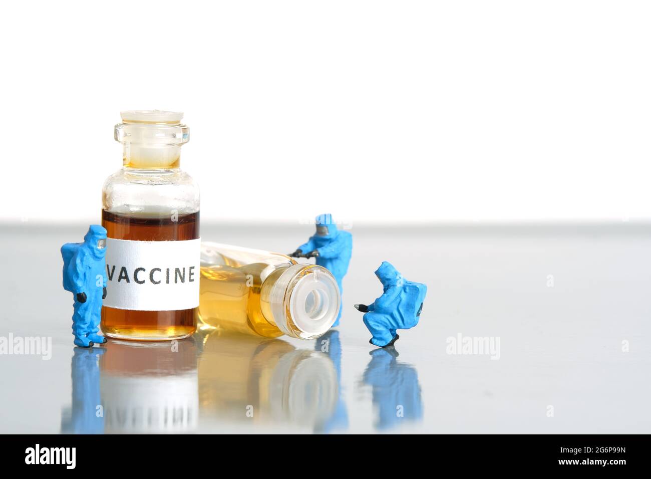 Miniatur Menschen Spielzeug Figur Fotografie. Test mit klinischen Impfstofftests. Eine Gruppe von Sanitätern mit einem Hasmatanzüge, der Impfampulle testet. Bildfoto Stockfoto