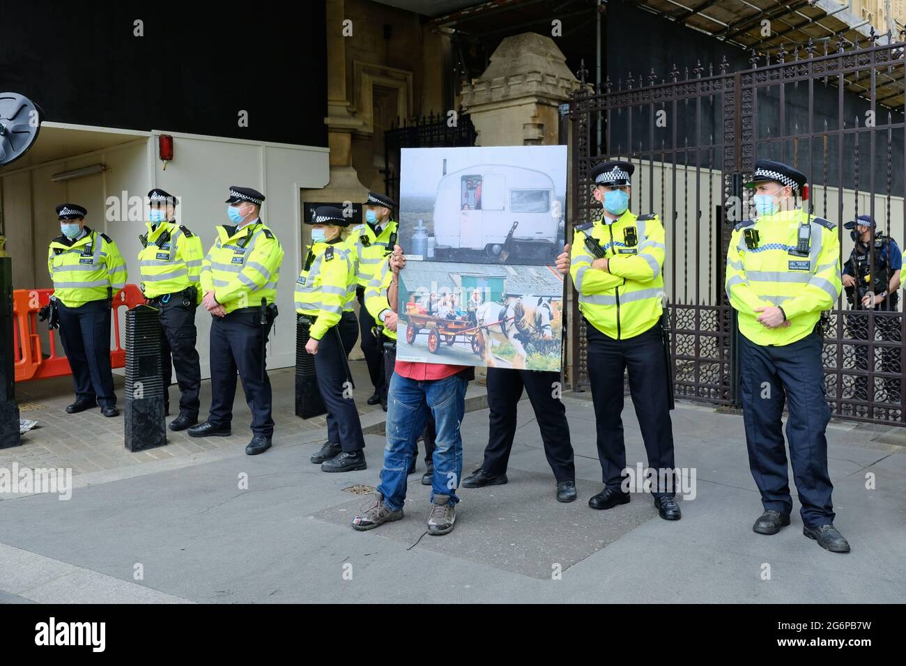 Vor dem Parlament steht ein Protestler, der „Kill the Bill“, mit einem Bild, das das Leben von Reisenden zeigt. Der Gesetzentwurf stellt eine Bedrohung für die Lebensweise der Reisenden dar. Stockfoto