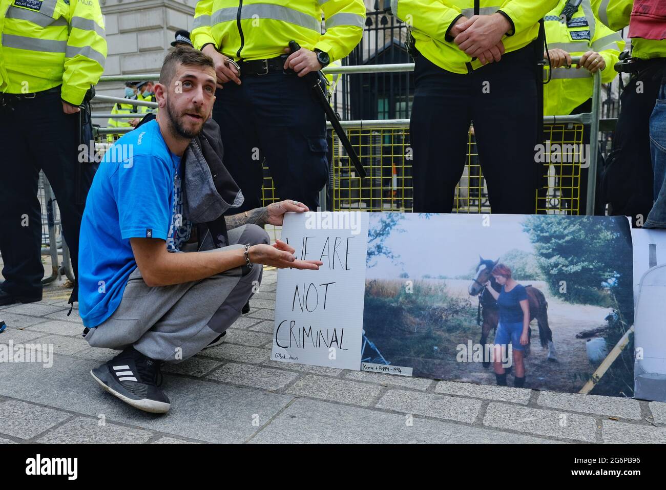 Ein Protestler hockt mit einem Plakat, das die Lebensweise des Reisenden darstellt, und droht, von dem vorgeschlagenen Verbrechen bedroht zu werden und den Gesetzentwurf zu verurteilen. Stockfoto
