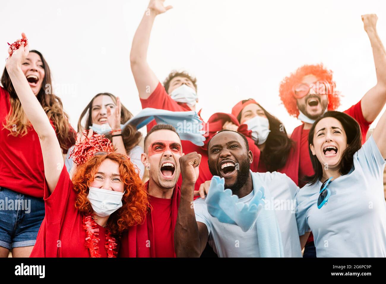 Eine Gruppe von multirassischen Unterstützern, die ihr Team im Stadion unterstützen Stockfoto