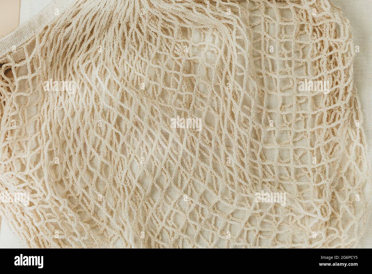 Wiederverwendbare, beigefarbene Baumwoll-Mesh-Taschen auf beigem Hintergrund. Umweltfreundliche Einkaufstasche. Nahaufnahme. Zero Waste Lebensmittelkonzept. Nachhaltig Stockfoto