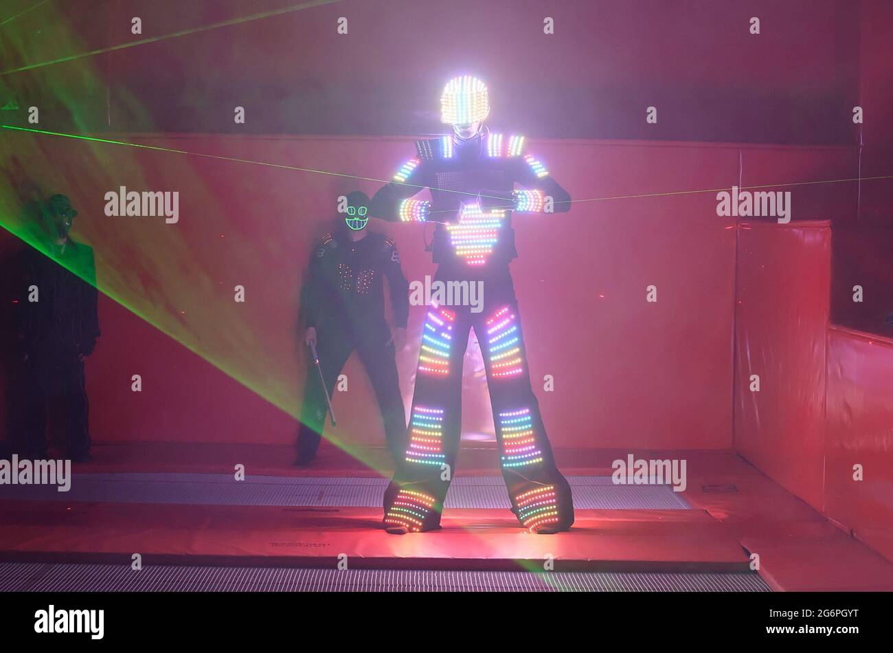Ein Tänzer in einem farbigen LED-Anzug tanzt mit einem Laser in den Händen  Stockfotografie - Alamy