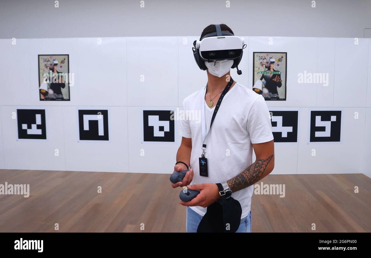 Stuttgart, Deutschland. Juli 2021. Ein Besucher des Kunstmuseums steht mit  einer Virtual-Reality-Brille in einem Raum, in dem nur QR-Codes an den  Wänden hängen. In 'Artiality' kann das Publikum virtuell in Bilder  eintreten.