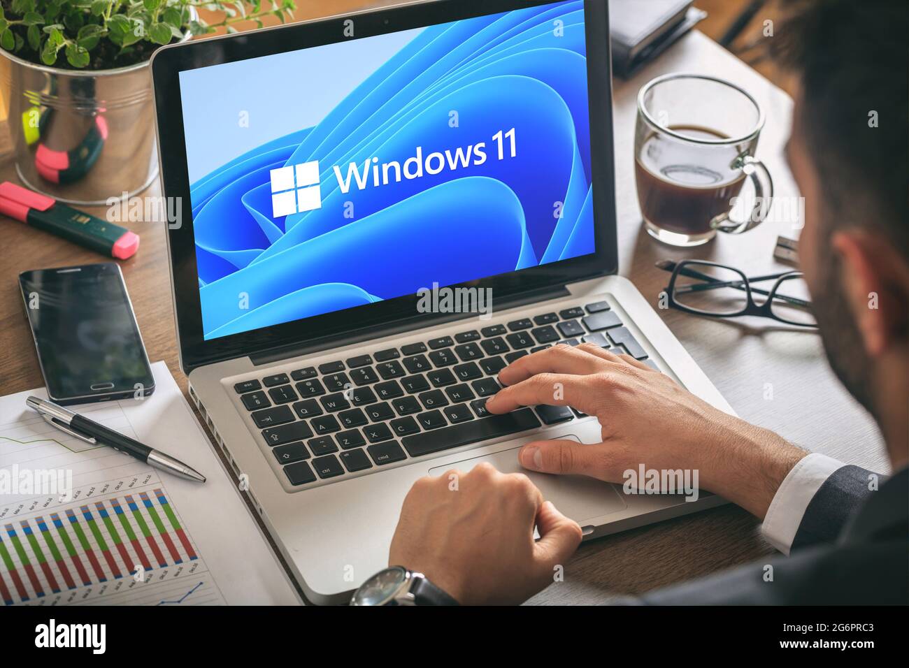 Griechenland Athen, Juli 8 2021. Mann arbeitet mit einem Laptop, Windows 11 neues Microsoft-Betriebssystem auf Computer-Display, Büro Schreibtisch Hintergrund. Stockfoto