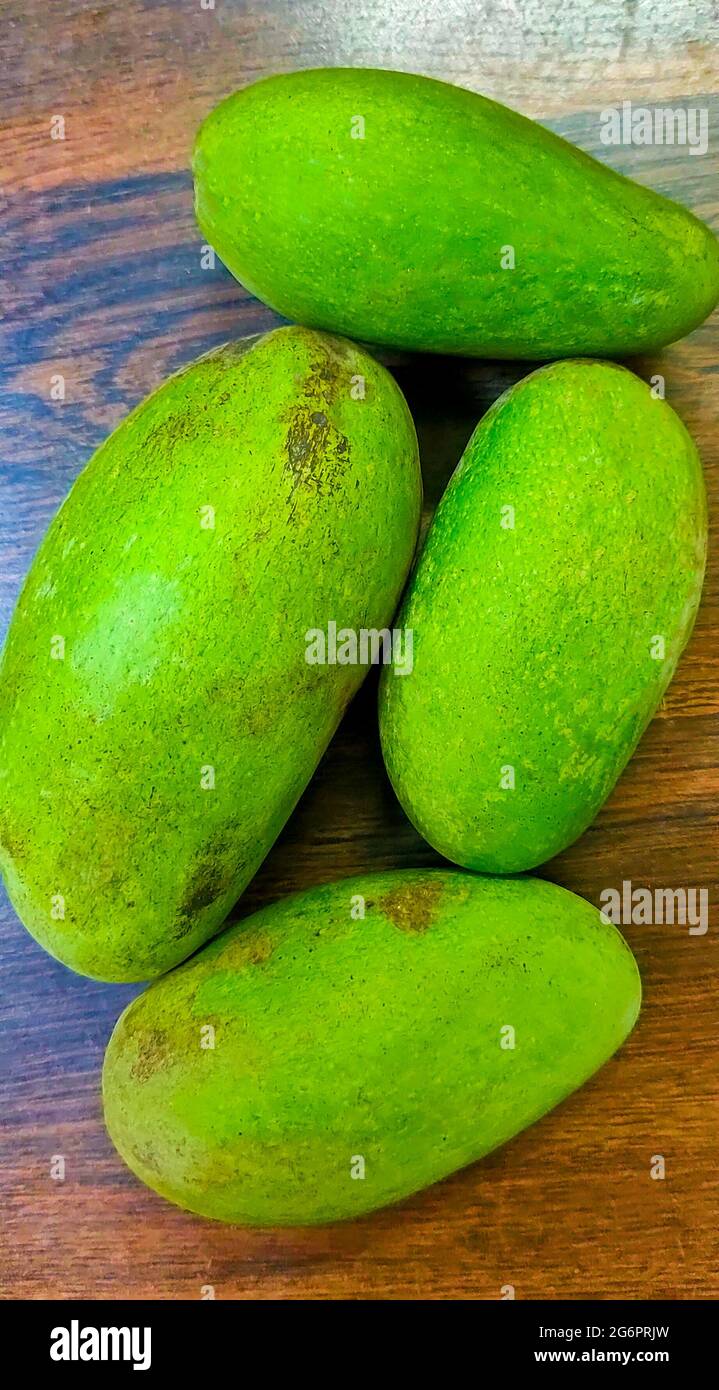 Tropische Früchte grüne Mango (Kachha aam) auf Holztisch Stockfoto