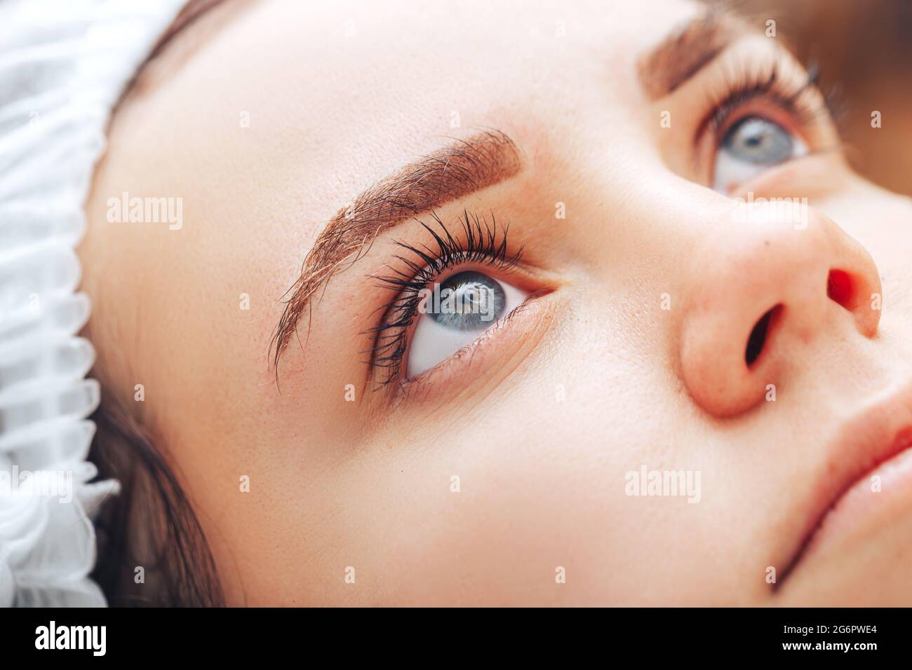 Junge Frau mit schönen Augenbrauen nach dem Eingriff permanente Make-up im Salon, Nahaufnahme Foto. Stockfoto