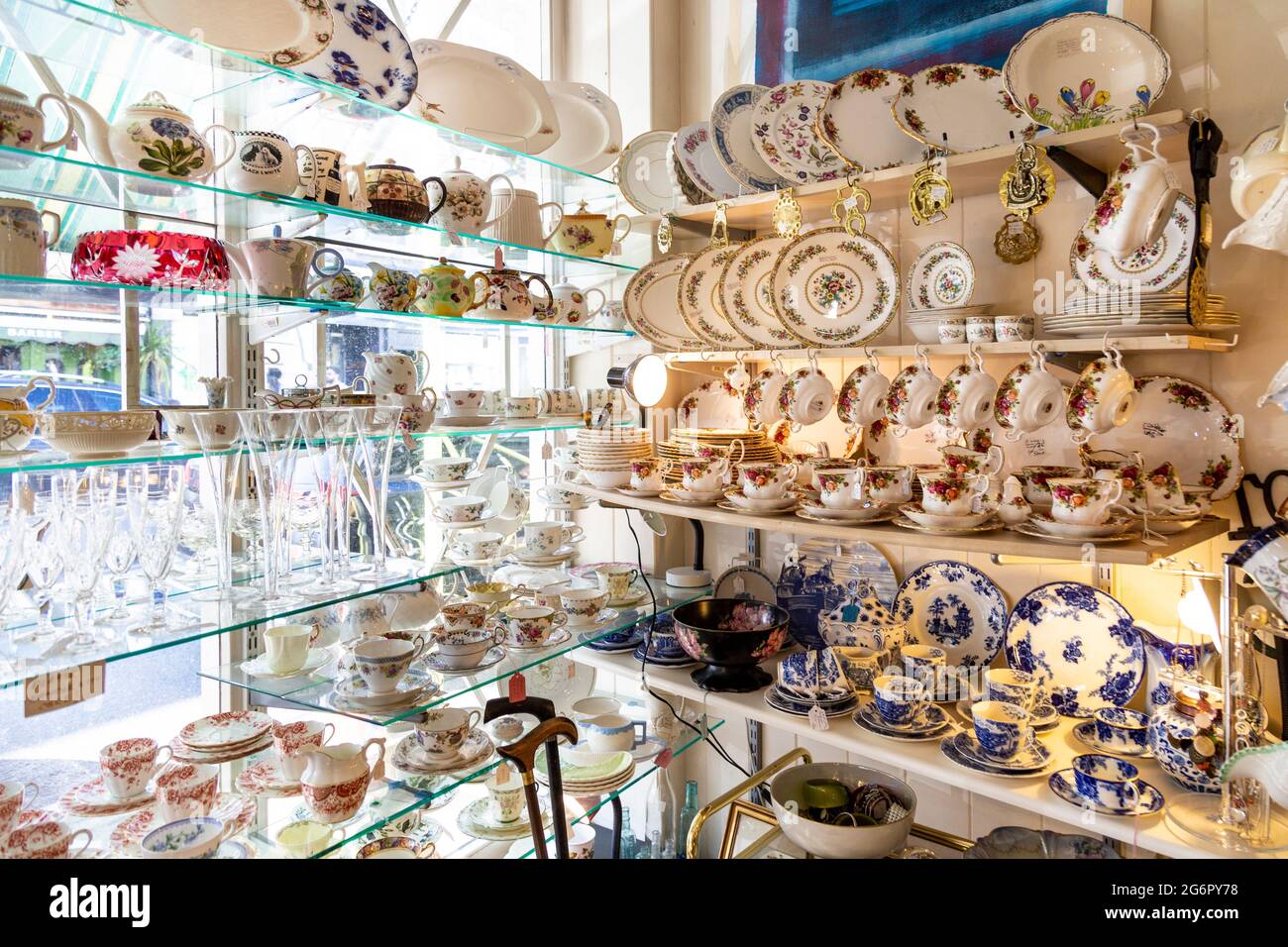 Ausstellung von Geschirr, Porzellan und Glaswaren in einem Antiquitätengeschäft (Hampton Court Emporium, East Molesey, UK) Stockfoto