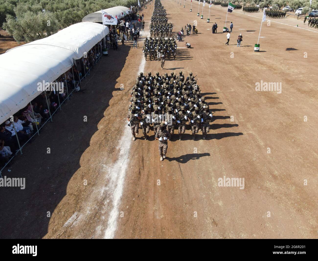 Scheich Al-Hadid, Aleppo. Syrien, 6. Juli 2021.Syrische Kämpfer marschieren in Säulen, fahren Dirt-Bikes und fahren Pick-up-Trucks während einer Abschlussfeier in der Nähe der nördlichen Stadt Afrin für neue Rekruten, die der Sultan-Süleyman-Schah-Brigade der Zweiten Legion der Nationalen Armee, den Wölfen des Nordens, beitreten Stockfoto