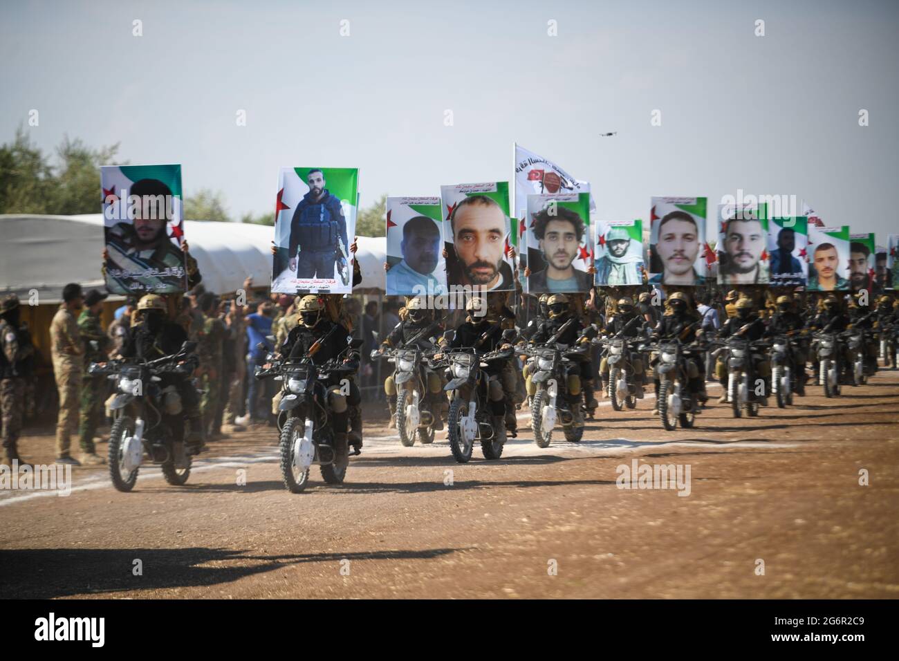 Scheich Al-Hadid, Aleppo. Syrien, 6. Juli 2021.Syrische Kämpfer marschieren in Säulen, fahren Dirt-Bikes und fahren Pick-up-Trucks während einer Abschlussfeier in der Nähe der nördlichen Stadt Afrin für neue Rekruten, die der Sultan-Süleyman-Schah-Brigade der Zweiten Legion der Nationalen Armee, den Wölfen des Nordens, beitreten Stockfoto