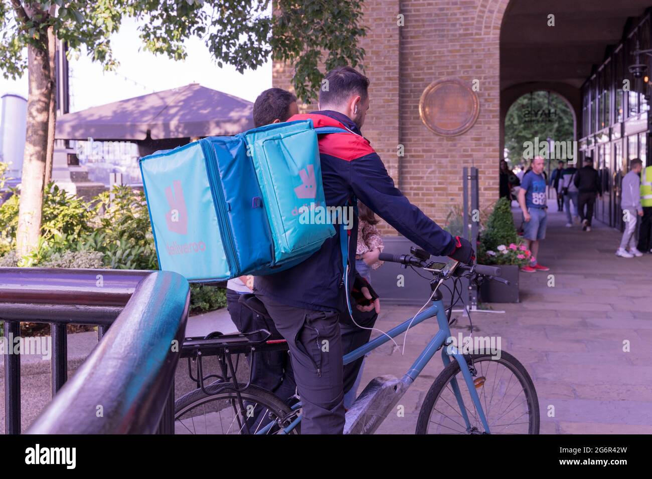 Deliveroo-Kurier auf seinem Fahrrad, der heiße Lebensmittel an den Kunden, London, South Bank, England, Großbritannien, liefert Stockfoto