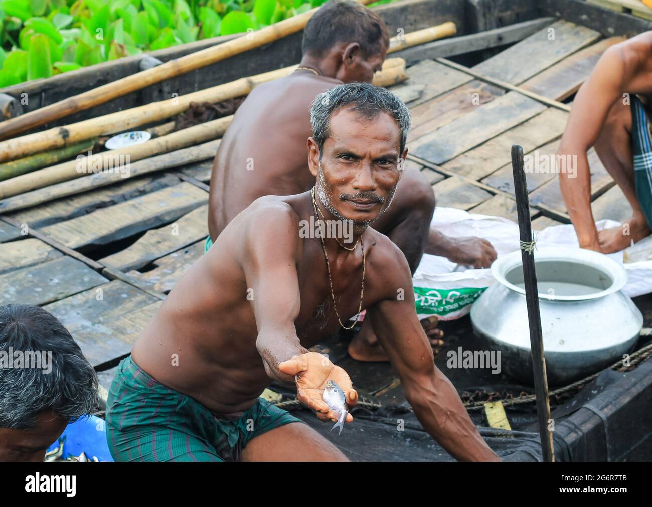 Fischer aus Bangladesch fingen Fische. Fisch zur Hand. Angeln auf dem Fluss mit Fischernetzen. Das Leben der traditionellen Fischer. Angeln im Fluss. Stockfoto