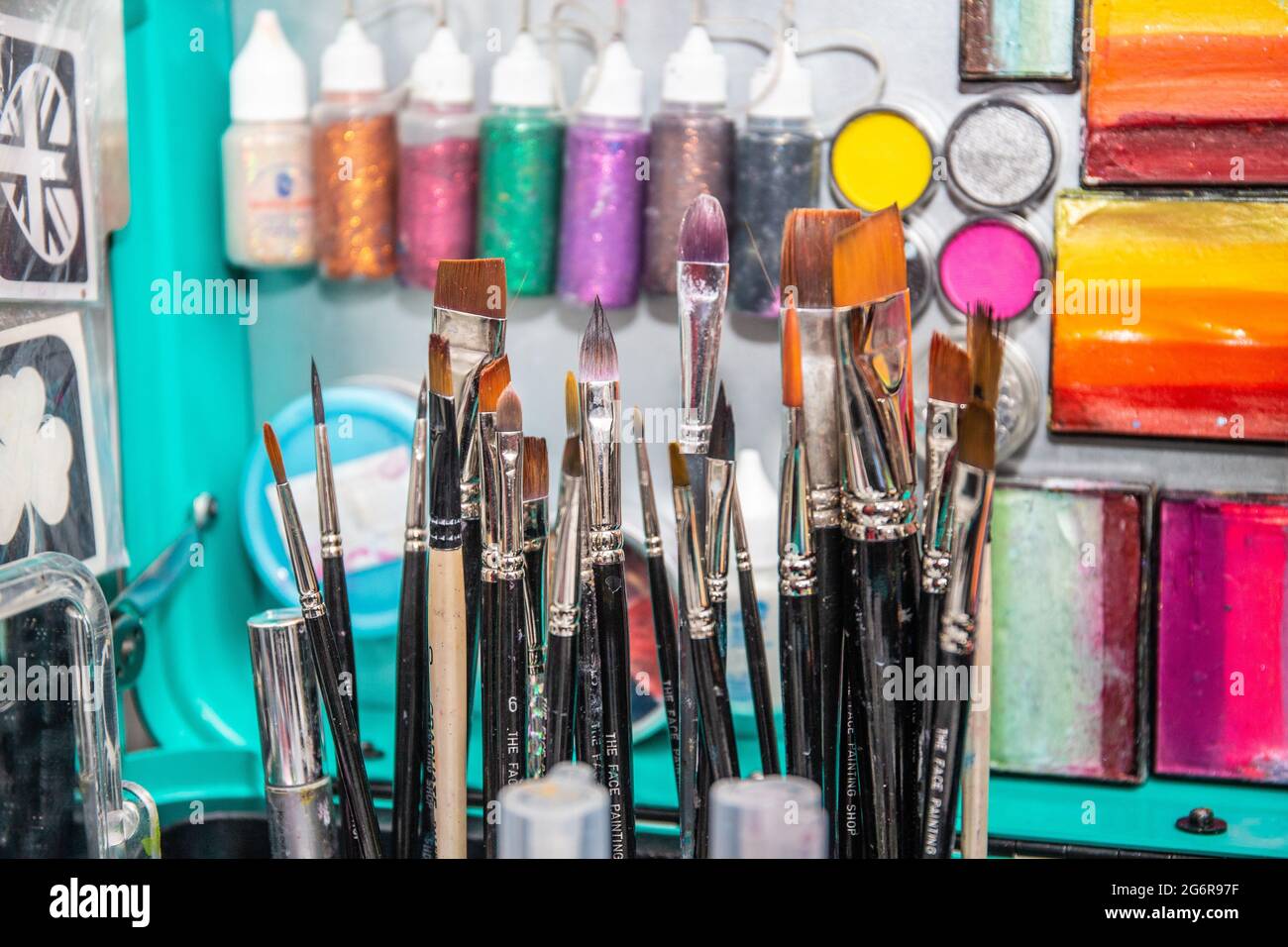 Nahaufnahme von Farben, Schablonen, Bürsten und anderen Geräten, die für die Gesichtsmalerei verwendet werden. Stockfoto