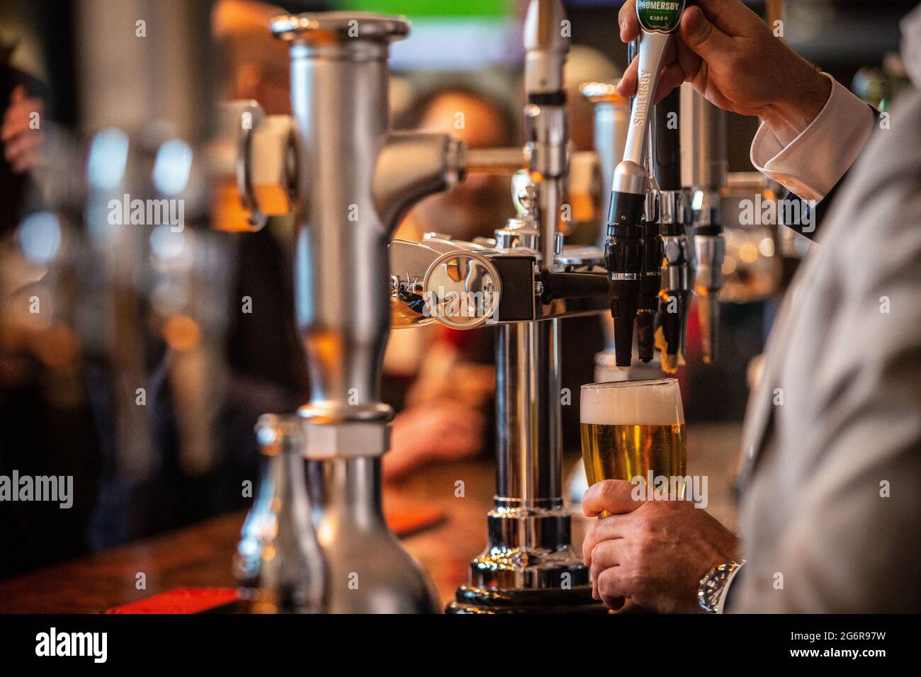 Ein Bier/Bier, das gegossen wurde, wurde hinter der Bar im Pub gesehen Stockfoto