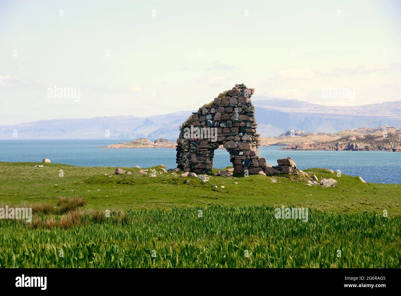 Ruinen eines Tores in einer alten Steinmauer, Iona, Schottland mit der Insel Mull dahinter Stockfoto