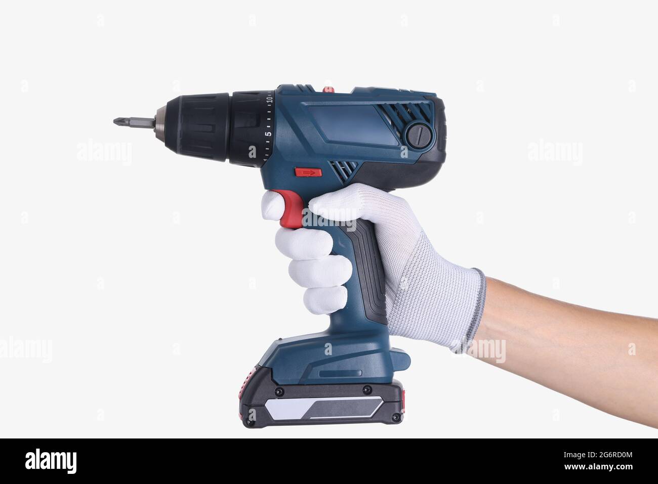 Master in Handschuh hält eine Bohrmaschine mit Bohrer auf weißem Hintergrund Stockfoto