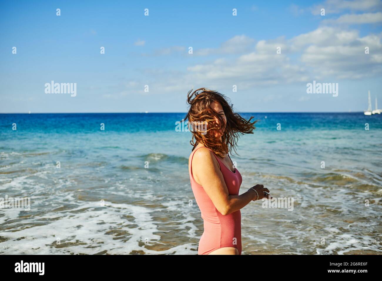 Glückliche Frau mit Spaß am Strand während der Sommerferien - Fokus auf weiblichen Rücken Stockfoto