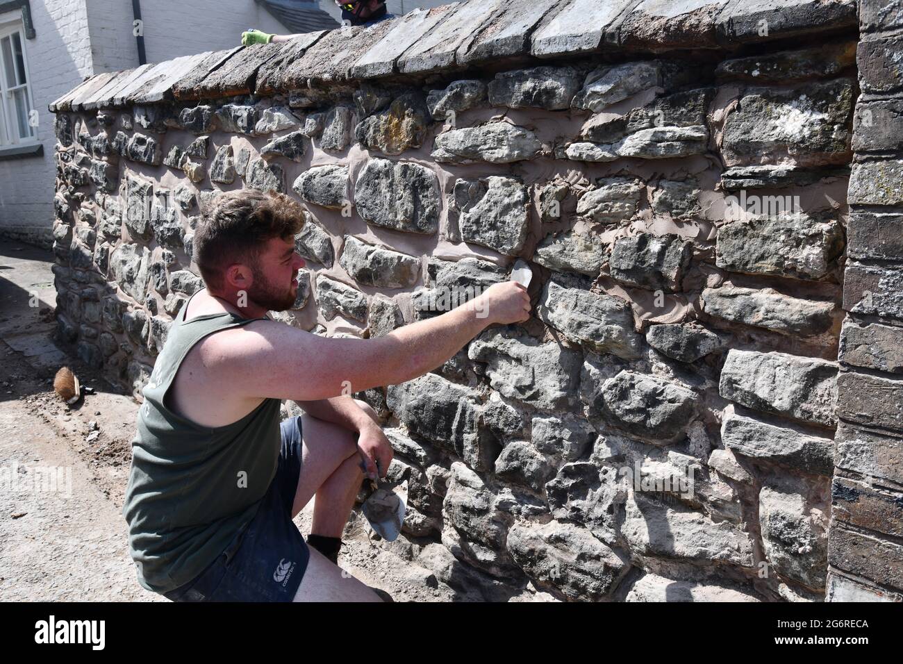 Bauarbeiter Baumeister Reparatur zeigen alte Steinmauer Großbritannien Stockfoto