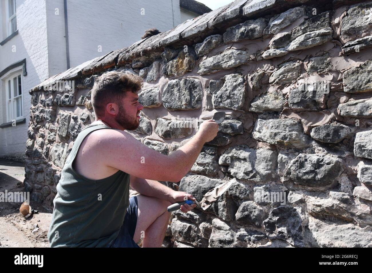 Bauarbeiter Baumeister Reparatur zeigen alte Steinmauer Großbritannien Stockfoto